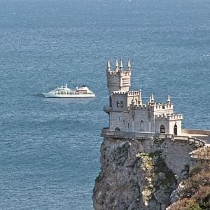 Castle on a cliff overlooking a ship at sea