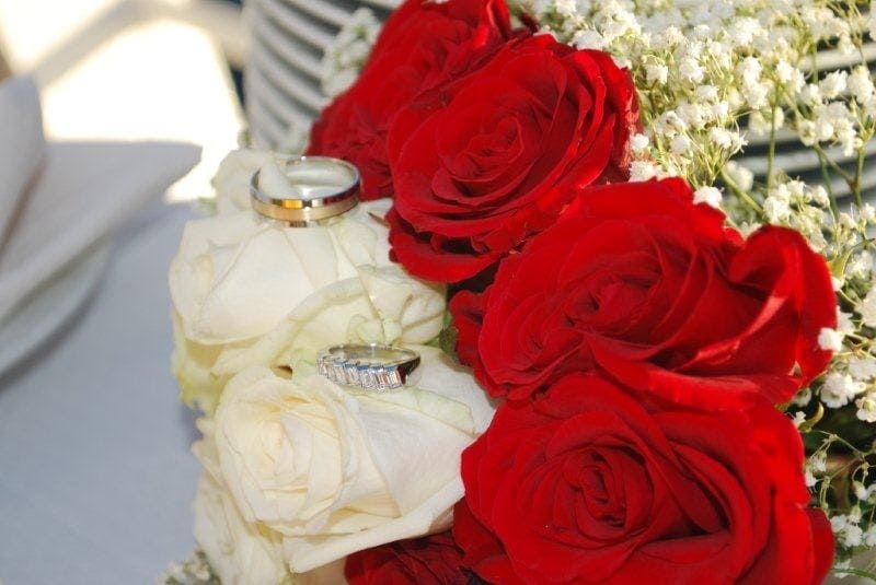 Two Wedding Rings On Top Of Roses