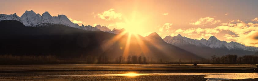 Sun setting over snowy mountains