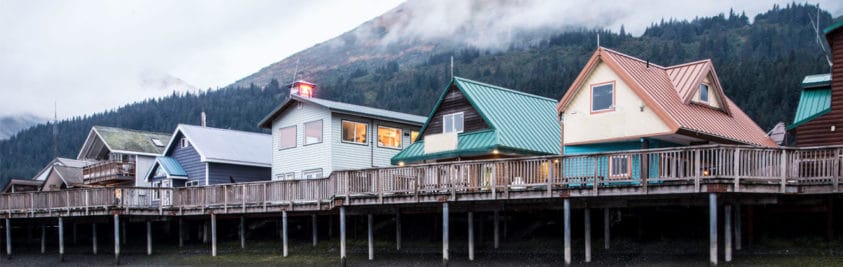 Colorful homes on stilts surrounded by green trees